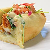 Hot dog de Rabas con quesos fundidos, rúcula, concassé de tomate y distintas salsas